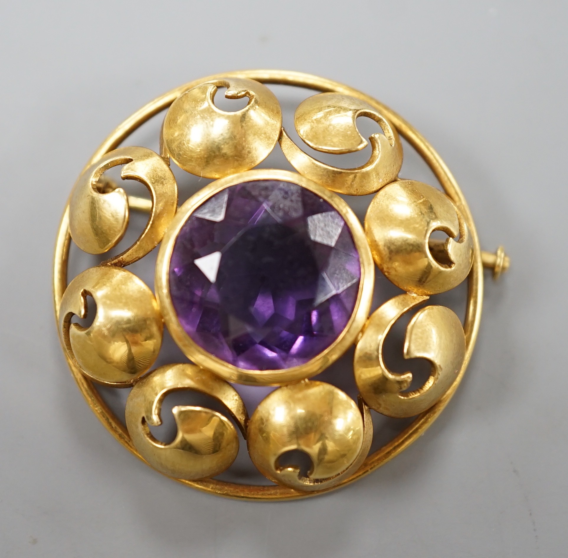 A continental 750 yellow metal circular amethyst set circular brooch, 31mm, gross weight 12.2 grams.